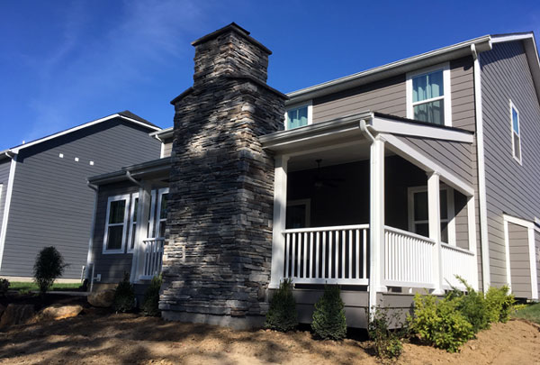 Covered porch addition with white columns and railings