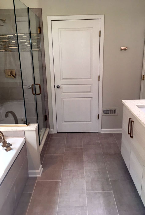 Tiled shower with mosaic accent band and Champagne Bronze fixtures